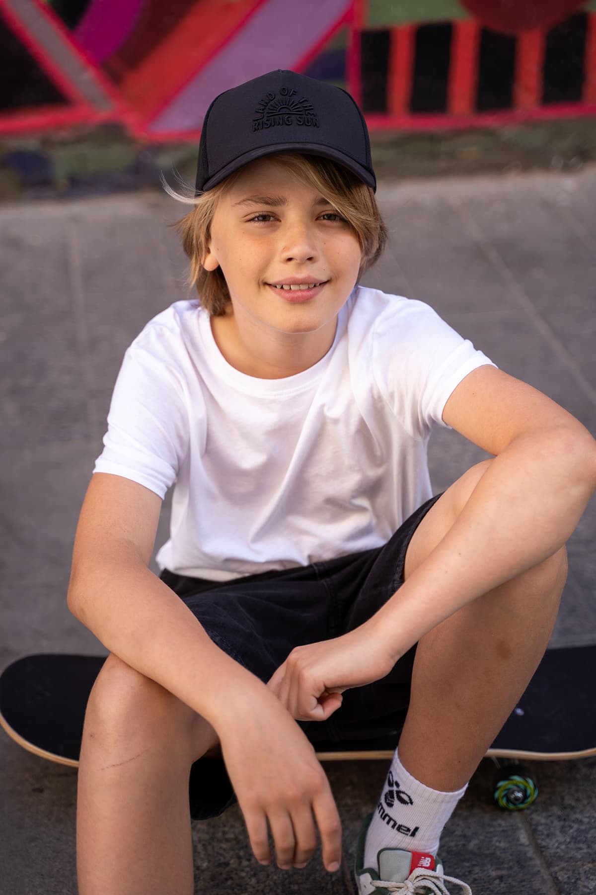 Professional model test featuring a teenager sport fashion model in natural light with skateboard